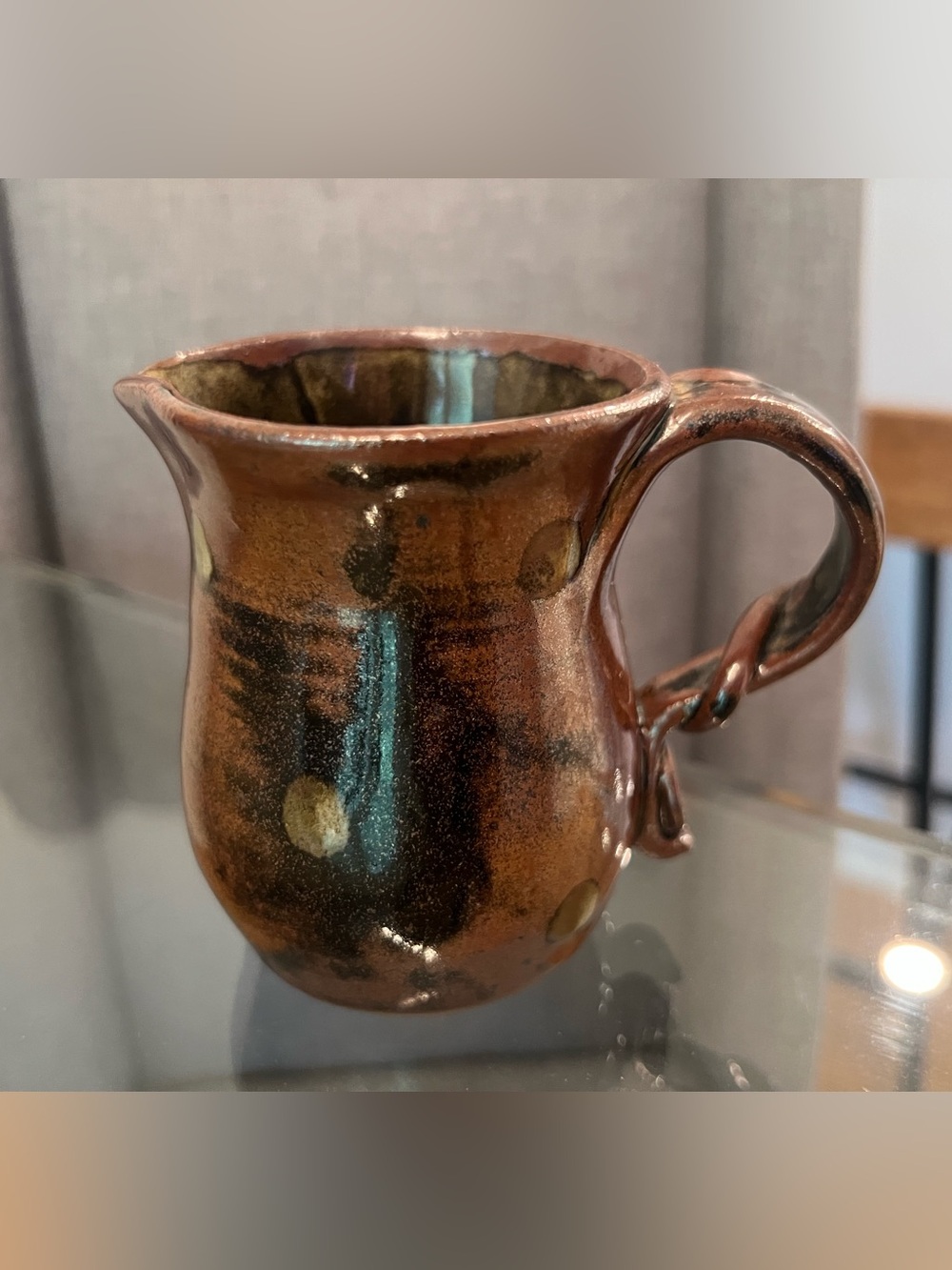Stamped “bro” pottery creamer pitcher with a speckled dark brown and black glaze